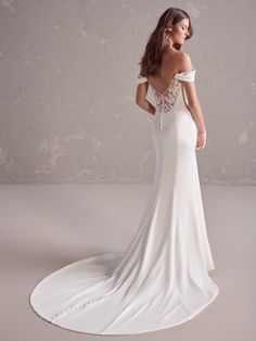 a woman in a white wedding dress is standing on a circular floor with her back to the camera