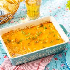 a blue casserole dish filled with cheesy potatoes and carrots