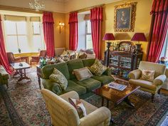 a living room filled with furniture and red curtains