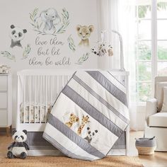 a baby's room with a crib, teddy bear and wall decals