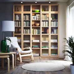 a living room filled with lots of furniture and bookshelves next to a window