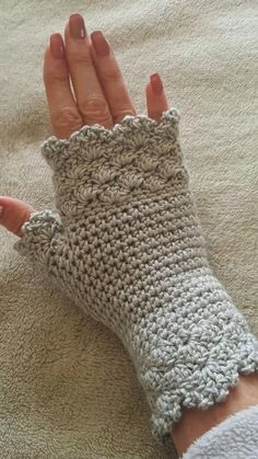 a woman's hand with crocheted fingerless gloves