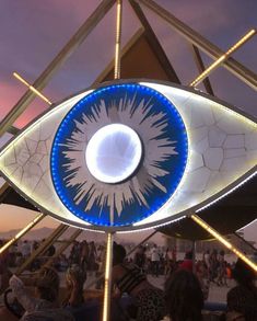 an eye sculpture with people sitting around it