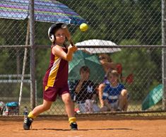 a young boy swinging a baseball bat at a ball