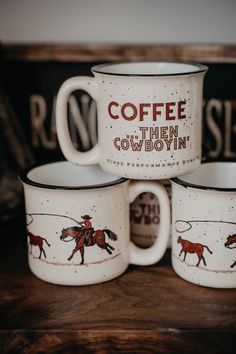 three coffee mugs sitting on top of a wooden table with the words coffee then cowboys painted on them