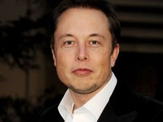 a close up of a person wearing a suit and tie with a tree in the background