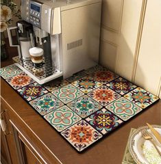 a coffee machine sitting on top of a kitchen counter next to a plate and cup