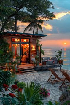 a small house sitting on top of a sandy beach next to the ocean at sunset