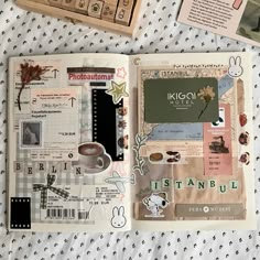 an open book with pictures and words on the pages next to some other items that are laying on a bed