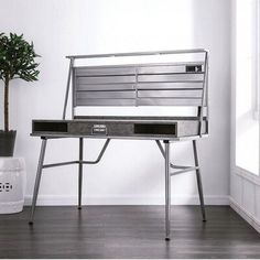 a metal bench sitting on top of a hard wood floor next to a potted plant