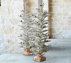 a small white christmas tree sitting on top of a stone floor