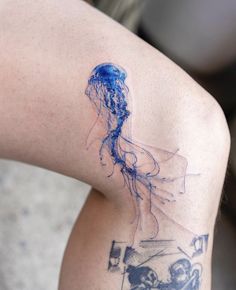 a woman's arm with a blue ink drawing of a jellyfish on it