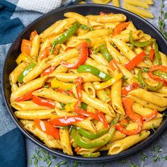 a bowl filled with pasta and peppers on top of a table