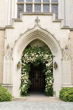 an entrance to a church with white flowers on it