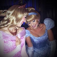 two young women dressed as princesses are looking at each other's eyes and smiling