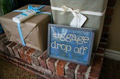 two wrapped presents sitting on top of a brick fireplace next to a sign that says huggage drop off