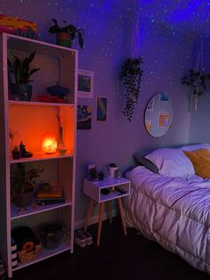 a bed room with a neatly made bed next to a night stand and some plants