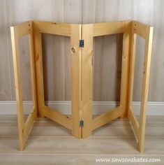 an open wooden door sitting on top of a hard wood floor next to a wall