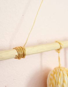 a ball of yarn hanging from a wooden rod