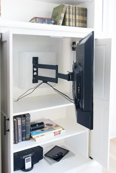 there is a tv and some books on the shelf in the room with it's door open