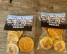 two plastic bags filled with gold colored tokens on top of a wooden table next to each other