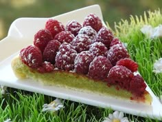 a slice of raspberry cheesecake on a plate with flowers in the background