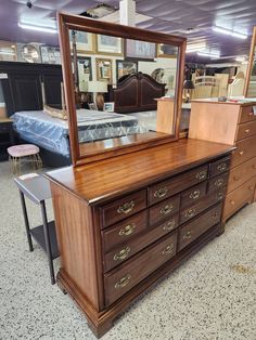 an antique dresser and mirror are on display at a furniture store with other items in the background