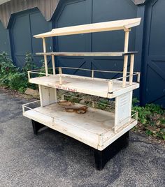 an old wooden stand with two shelves on the top and one shelf below it, outside