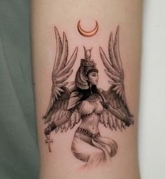 a tattoo on the arm of a woman with wings and a crescent above her head