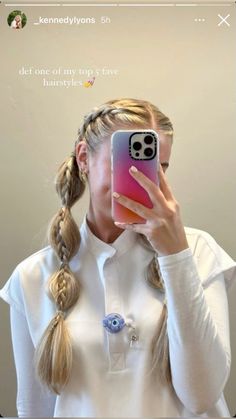 a woman taking a selfie in front of a mirror with her cell phone up to her face