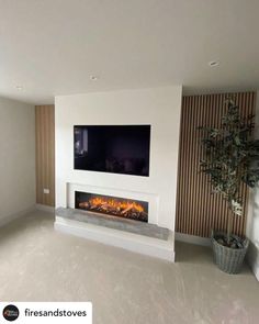 an empty living room with a fireplace and flat screen tv on the wall above it