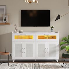 a television mounted on the wall above a white cabinet with yellow doors and drawers in a living room