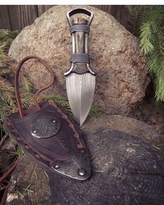 a knife and sheath sitting on top of a rock