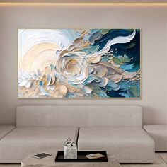 a living room with a couch, coffee table and large painting on the wall above it