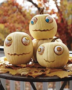 three pumpkins with googly eyes are stacked on top of each other