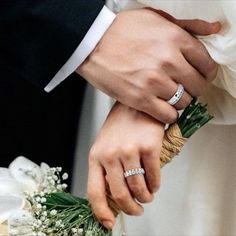 the bride and groom are holding each other's hands with wedding rings on their fingers