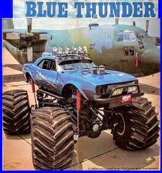 a blue thunder monster truck parked in front of an airplane with the words blue thunder on it