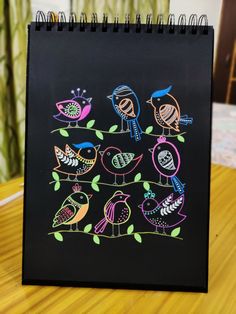 a black notebook with colorful birds on it