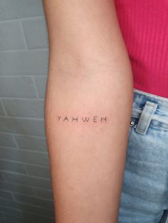 the word yahweh is written in cursive font on someone's arm