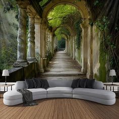 a couch sitting on top of a wooden floor next to a wall covered in vines