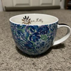 a blue and white coffee cup sitting on top of a counter