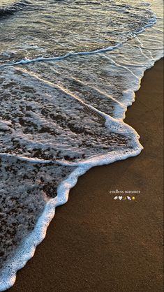 an ocean beach with waves coming in to shore and the sun shining on the water