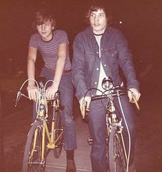 two young men riding bikes in the dark