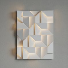 an abstract piece of art made out of white paper with light coming from the top