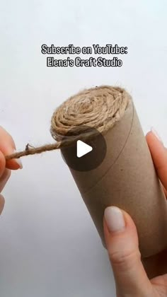 someone is holding a roll of twine and pulling it from the end with their thumb