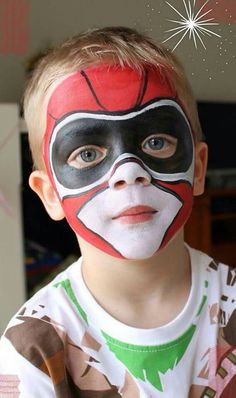 a young boy with his face painted like a ninja mask and fireworks in the background