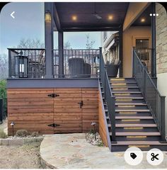 a house with stairs leading up to the front door and second story deck area on top of it