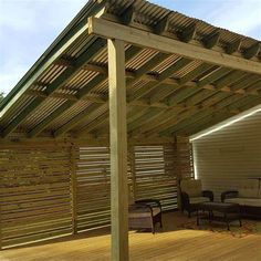 an outdoor living area with wood flooring and wooden slatted walls on the roof