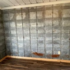 an empty room with wood flooring and metal studs on the wall behind it