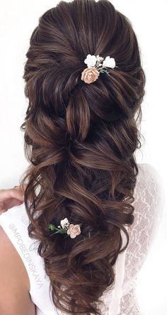 the back of a woman's head with flowers in her hair, wearing a wedding dress